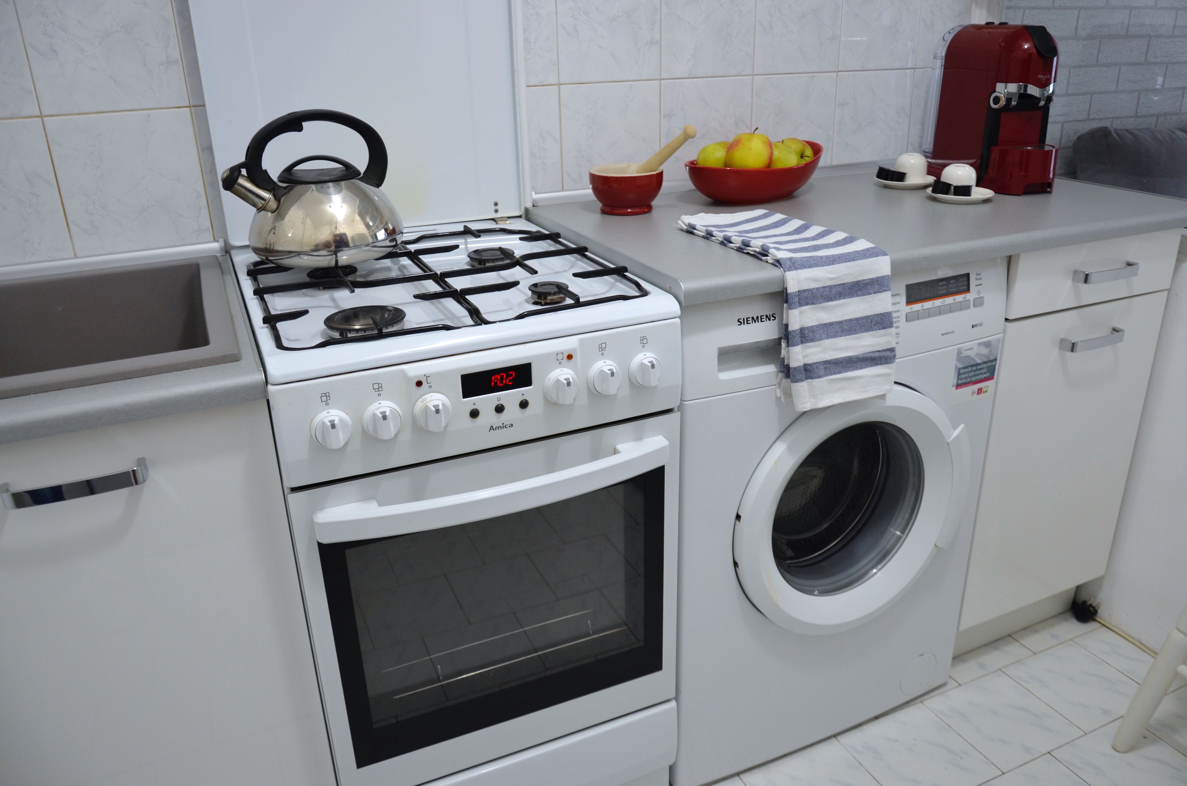 Una cocina con una estufa a gas Siemens, un horno y una lavadora.
