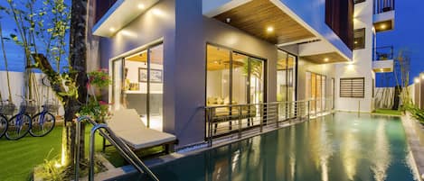 Alberca al aire libre y camastros