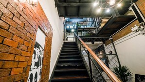 Eine Treppe mit einer Backsteinwand an einer Seite und einem Metallgeländer an der anderen.
