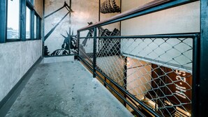 Eine Treppe mit Metallgeländer, einem Betonboden und einer Wand mit einem großen Wandgemälde.