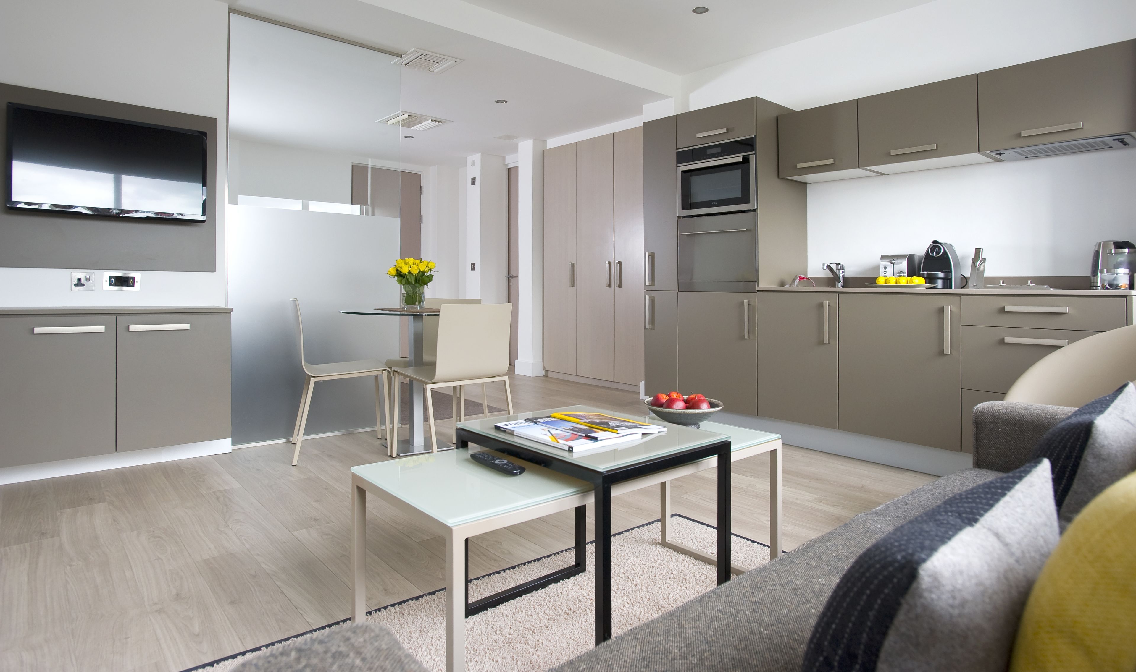 A modern kitchen with a built-in oven, microwave, and a coffee maker on the counter.