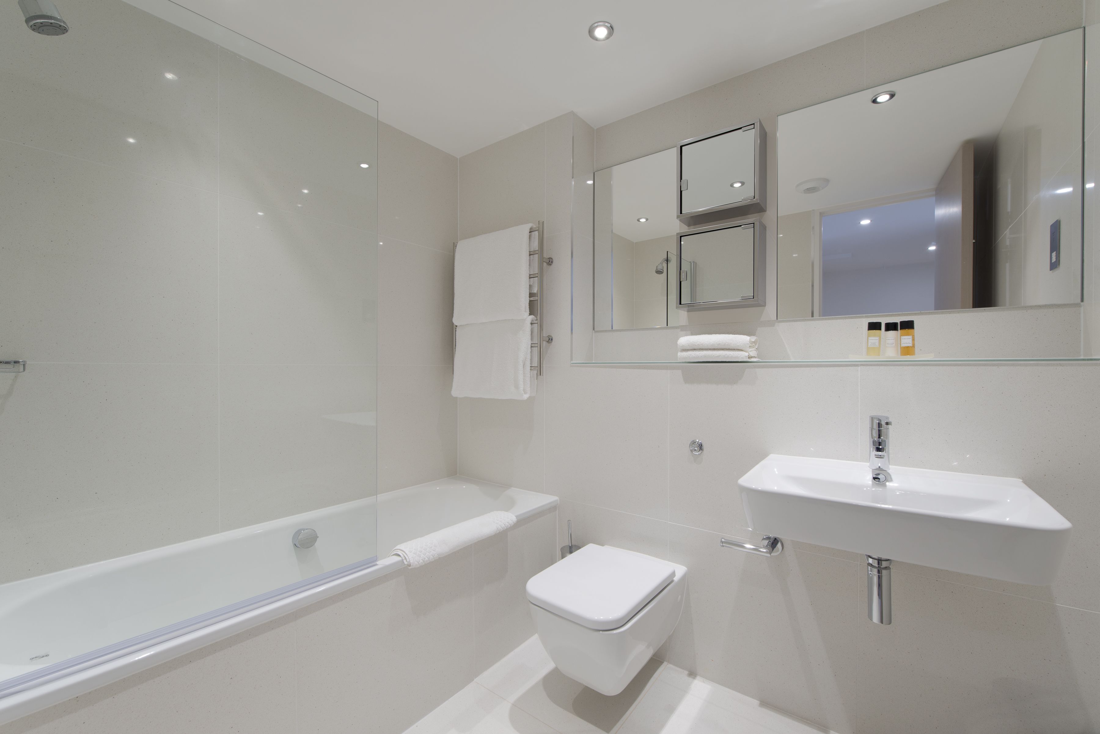 A modern bathroom with a bathtub, toilet, and sink.
