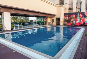 A swimming pool with lounge chairs and a bar area. - DoubleTree by Hilton Dubai Al Jadaf (Dubai)