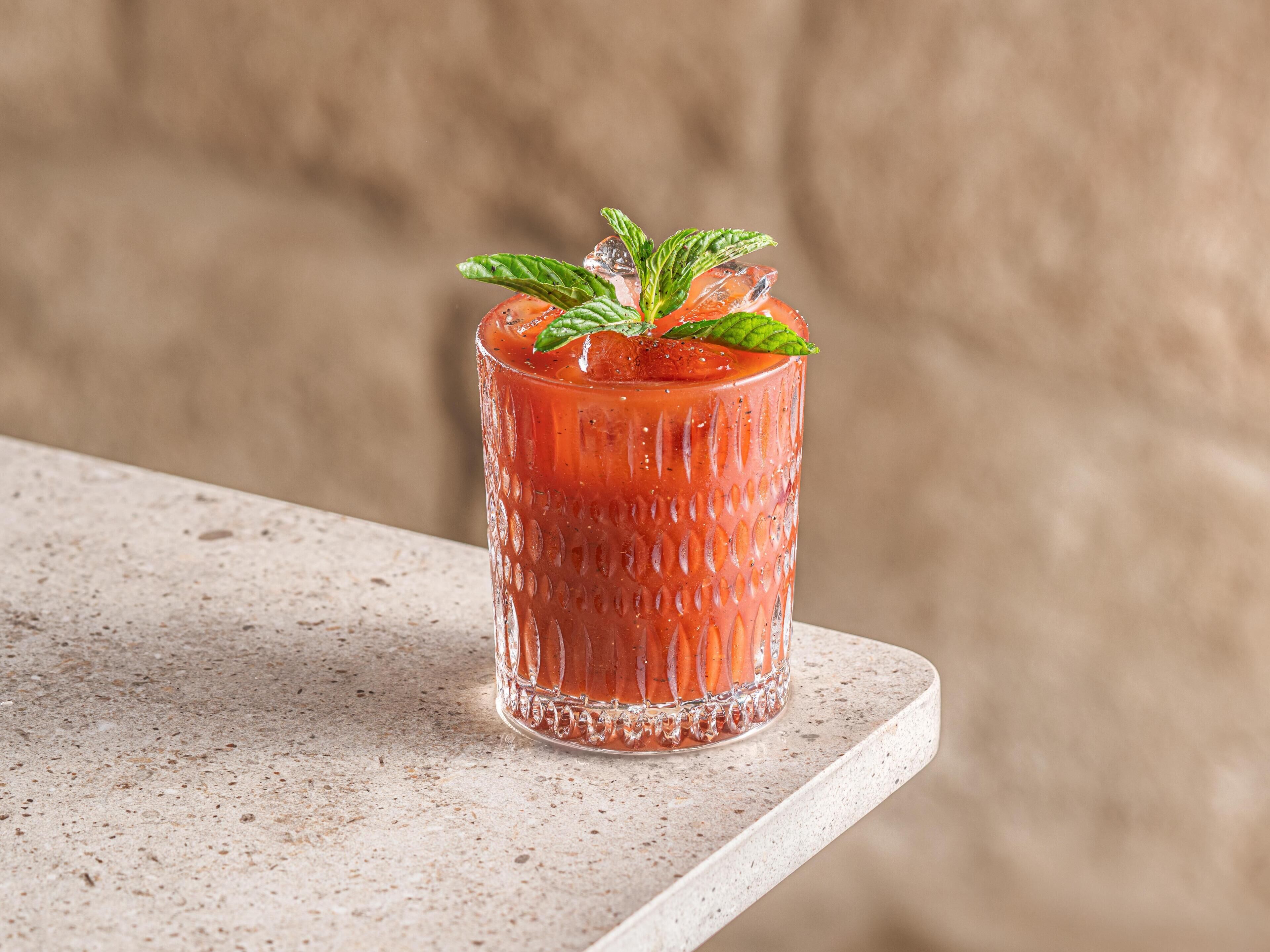 A glass with a textured pattern, placed on a speckled surface.