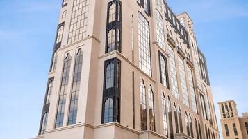 A tall, beige building with large windows and a corner entrance.