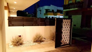 A gated entrance with a geometric metal gate and a wall-mounted panel. - Riva 33 (Porto Cesareo)