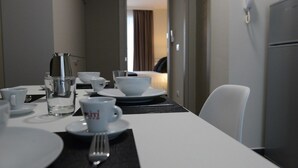 A hotel dining area with a table set for two, including plates, cups, and cutlery. - Riva 33 (Porto Cesareo)