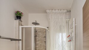 A modern bathroom with a shower enclosure, a sink, and a mirror. - La Candelaria (Pisa)
