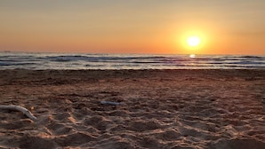 A beach with the sun setting over the ocean. - Casale Imperatore (Ragusa)