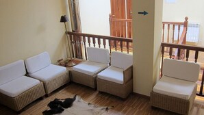 Un salon avec un ensemble de canapés, un petit tapis et un plancher en bois.