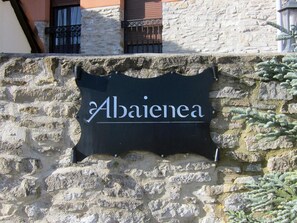 A stone wall with a sign that reads "Abaienea". - Agroturismo Abaienea (Vitoria-Gasteiz)