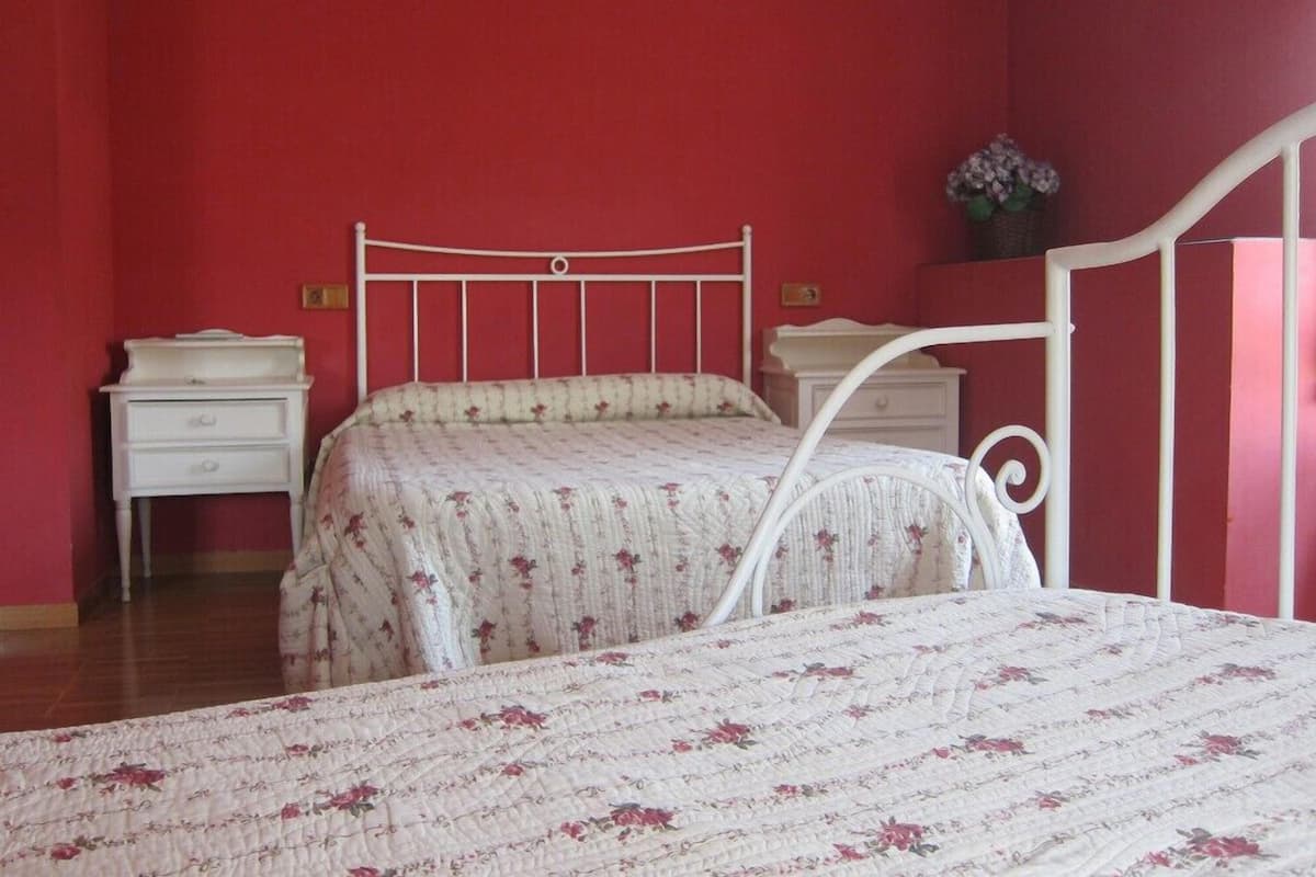 Une chambre à coucher avec un lit, deux tables de chevet et une commode.