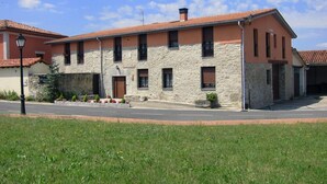 Un bâtiment à deux étages, doté d’une façade en pierre et d’un toit recouvert de tuiles rouges.