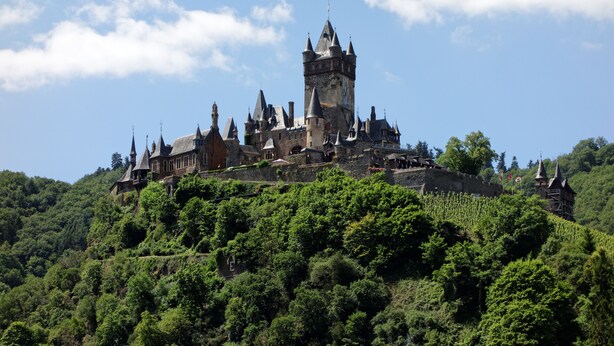 A castle on a hill with multiple towers and a large central tower. - Hotel Haus Sonnschein (Cochem)