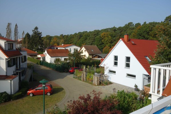 A residential area with houses, a red car, and a clear sky.