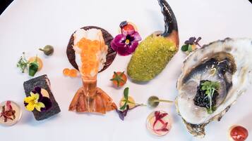 A plate with various food items including oysters, caviar, and a decorative toothpick.