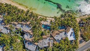 An aerial view of a resort with multiple bungalow-style buildings, a central swimming pool, and a beach with clear turquoise waters. - Seasense Boutique Hotel & Spa (Belle Mare)