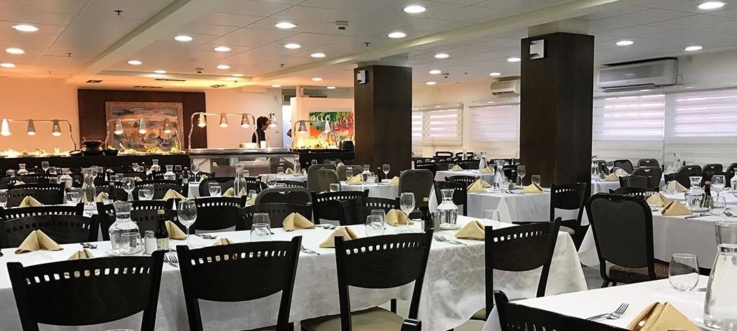 A dining area with multiple tables and chairs, arranged in rows.