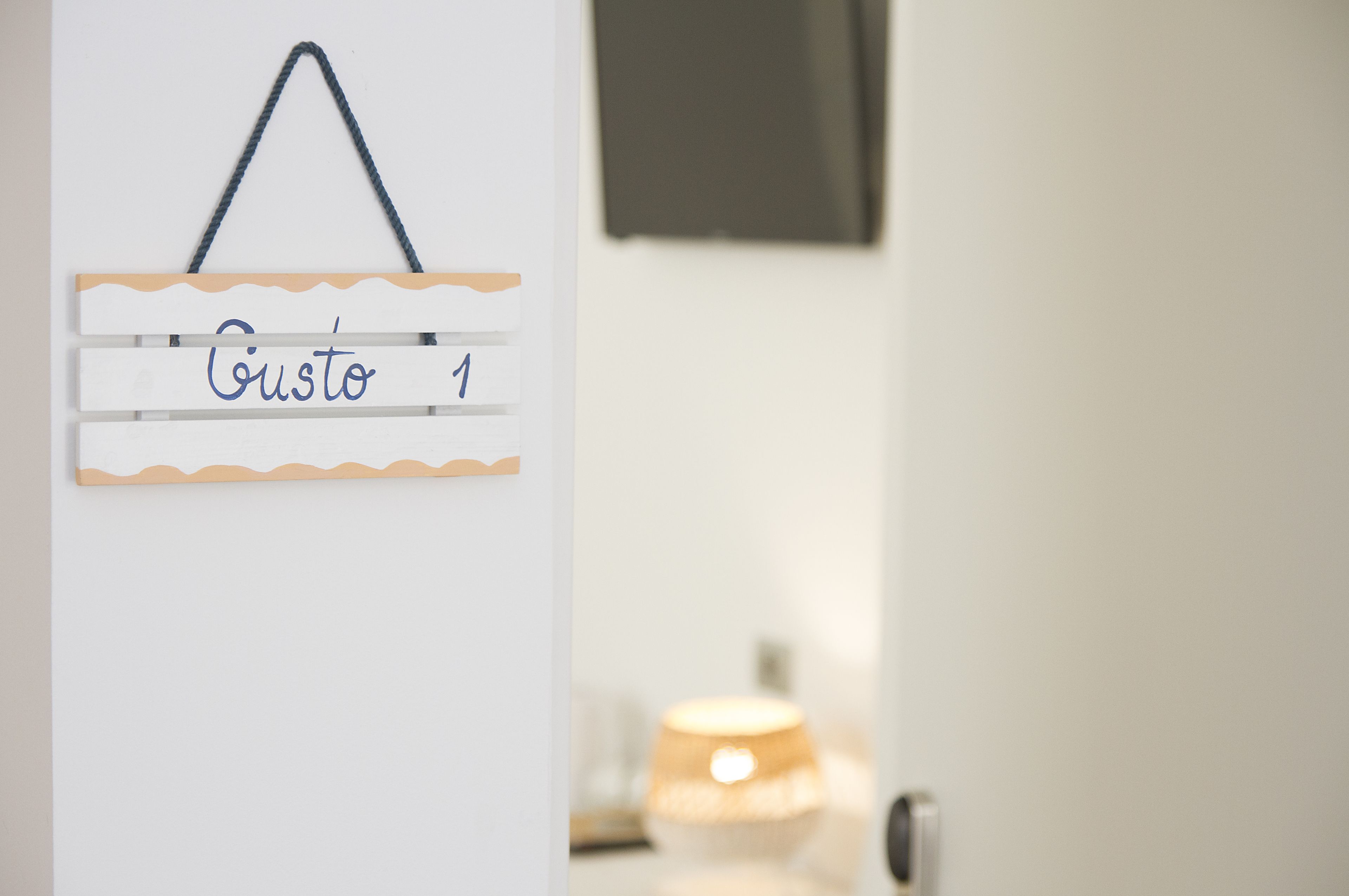A wall-mounted sign with the name "Gustavo" and a number "1".