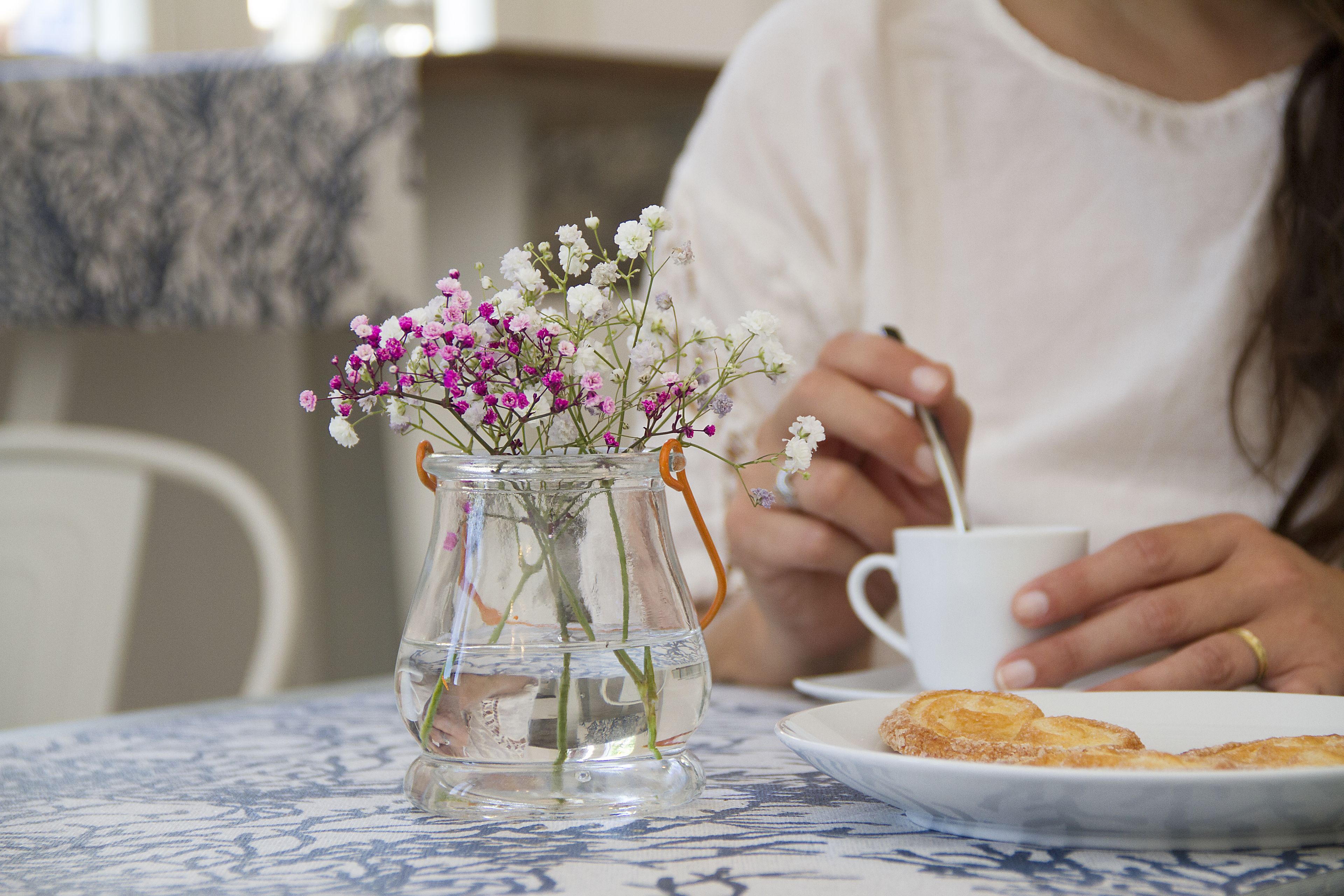 A clear glass vase with flowers on a table.