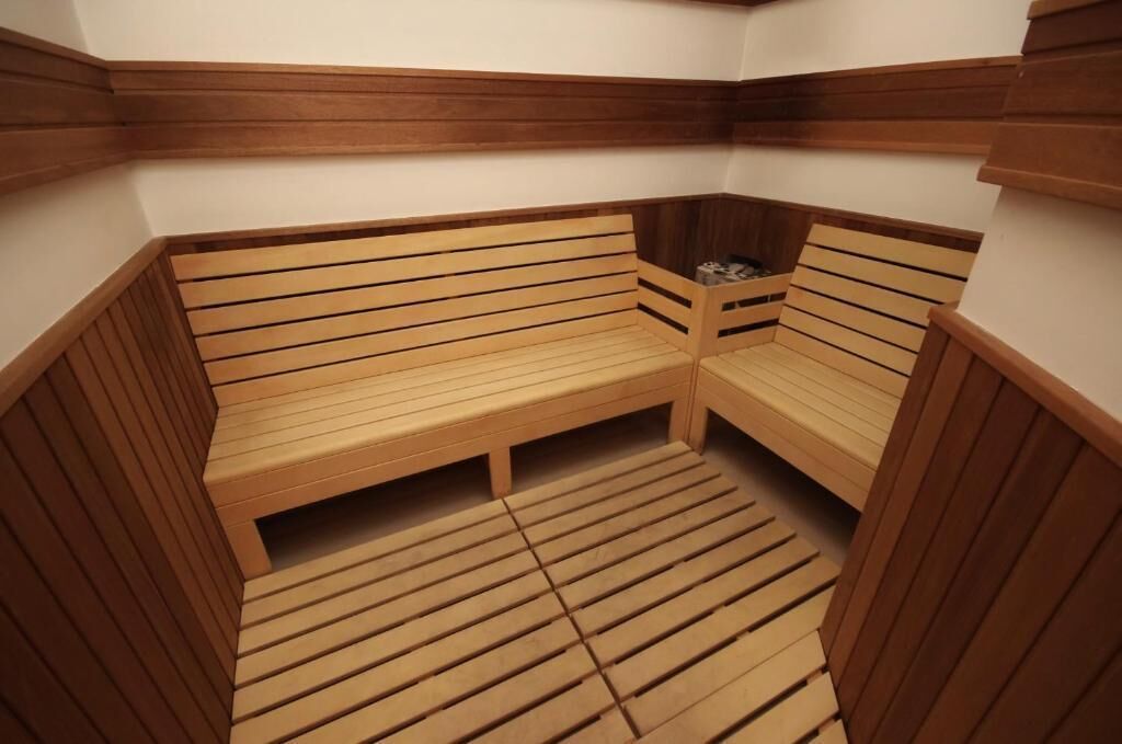 Una sauna con bancos de madera y suelo de tablones.