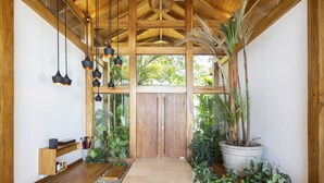 A wooden interior with a thatched roof, hanging pendant lights, a wooden bench, and potted plants. - Luxury Villa Melody- Santa Teresa beach  (Playa Santa Teresa)