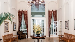 A spacious lobby with a round table, two wooden benches, a potted plant, and a chandelier. - PROMO PRICES!!CLEARWATER BEACH 2beds,2baths,FREE WI-FI/Parking in gated comunity (Clearwater)