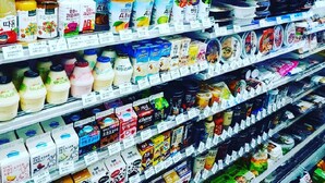 A grocery store aisle with various dairy products and packaged goods.