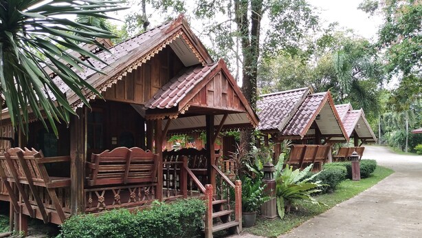 Wooden structures with thatched roofs, wooden benches, and a paved pathway. - Phetsangsom Resort (Klaeng)
