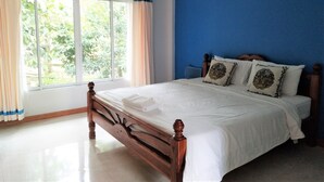A bedroom with a bed, curtains, and a view of greenery outside. - Phetsangsom Resort (Klaeng)