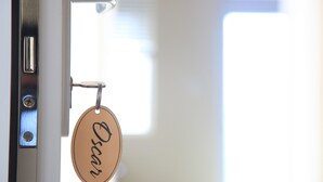 A door with a keyhole and a keychain with a name tag. - Oscar House (Xuan Huong - Da Lat)