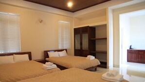 A hotel room with two beds, a wardrobe, and a bathroom visible through an open door. - Oscar House (Xuan Huong - Da Lat)