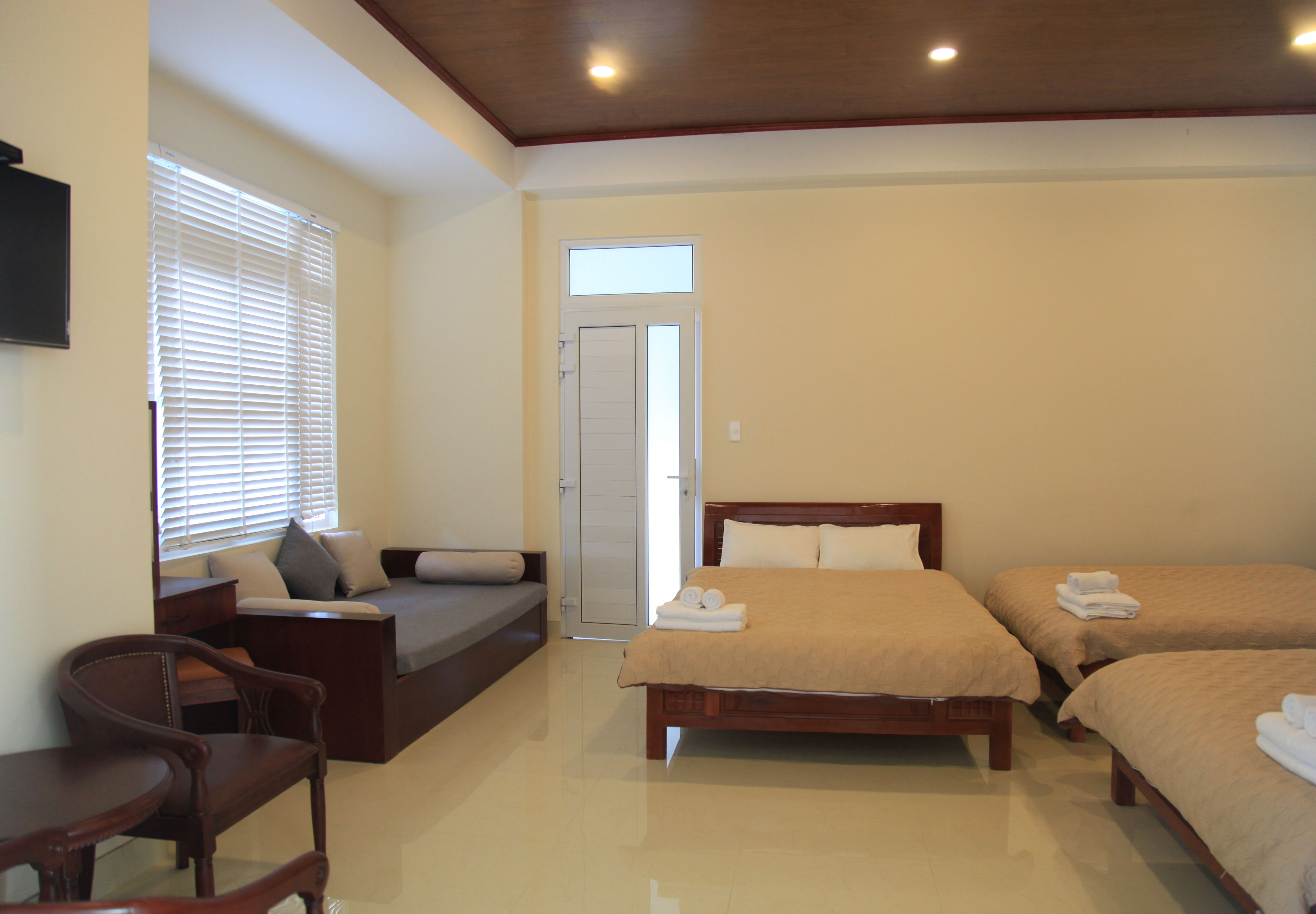 Una habitación de hotel con cama, sofá, escritorio y silla.