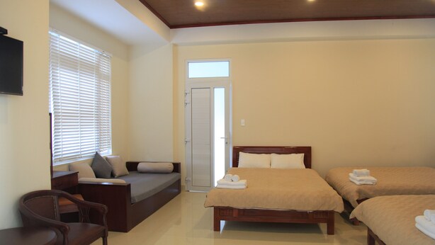 A hotel room with a bed, a sofa, a desk, and a chair. - Oscar House (Xuan Huong - Da Lat)