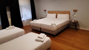 A hotel room with two beds, a TV, and a small bedside table with a phone. - Hotel Cantábrico de Llanes (Llanes)