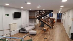 A spacious living area with a staircase, a sofa, and a coffee table. - Hotel Cantábrico de Llanes (Llanes)