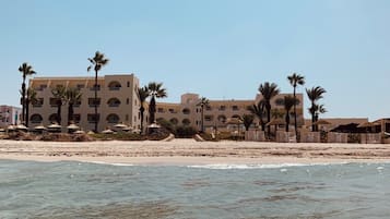 Playa privada, sillas reclinables de playa, sombrillas