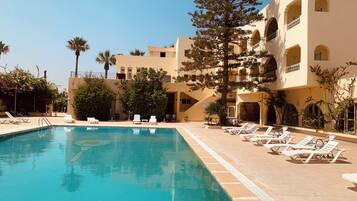 Een seizoensgebonden buitenzwembad en parasols bij het zwembad