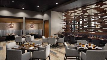 A modern restaurant with a mix of booth and table seating, wooden panel wall, and pendant lighting.