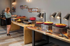 Guests can enjoy a wide selection of dishes at the buffet, featuring fresh fruits, vegetables, and prepared meals.