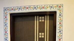 A door with a decorative border and a vertical stripe design. - Rising Shemesh (Udaipur)