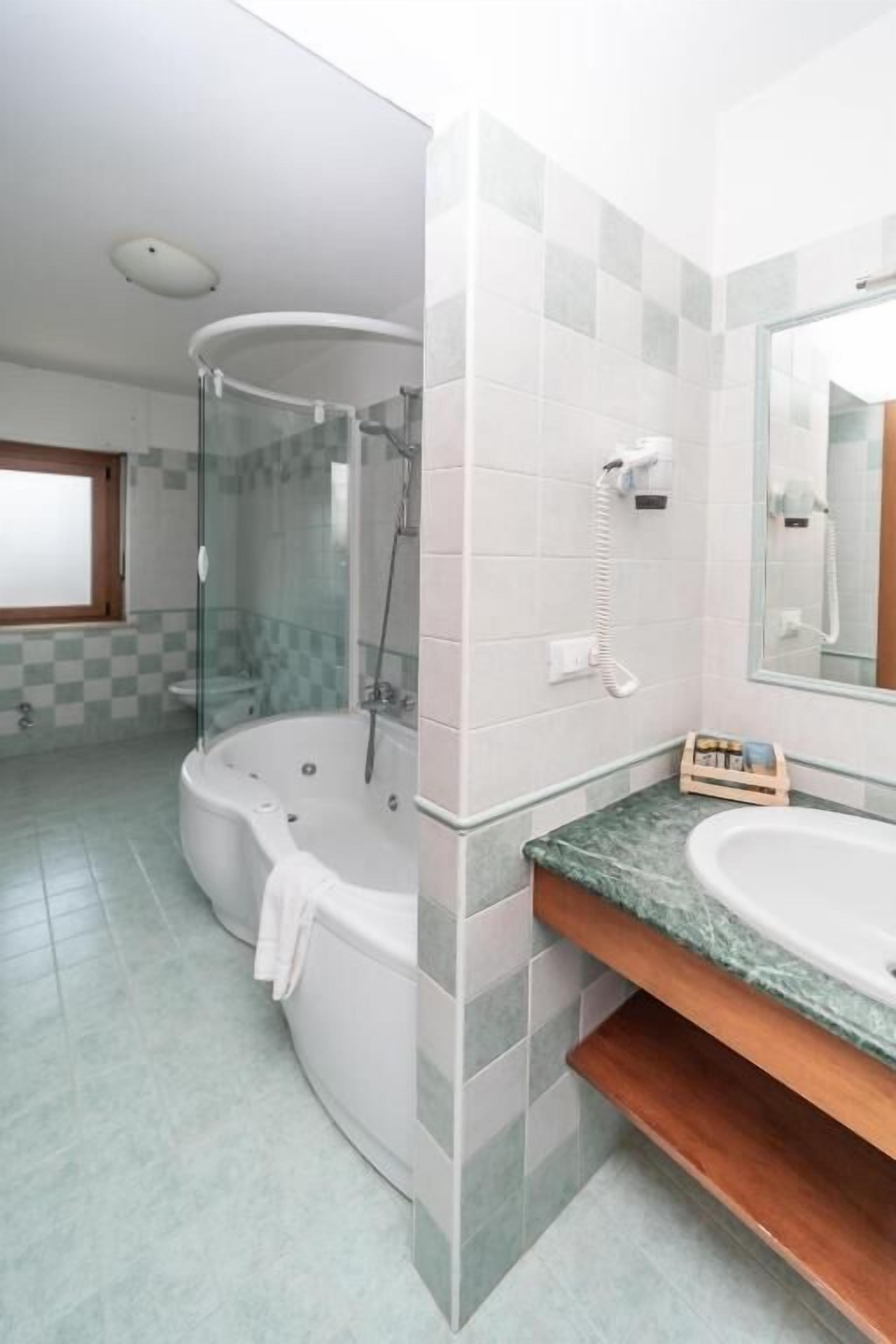 A bathroom with a glass-enclosed shower, a freestanding bathtub, and a vanity with a sink.