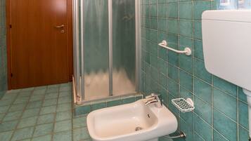 Une salle de bain équipée d’une douche, de toilettes et d’un bidet.
