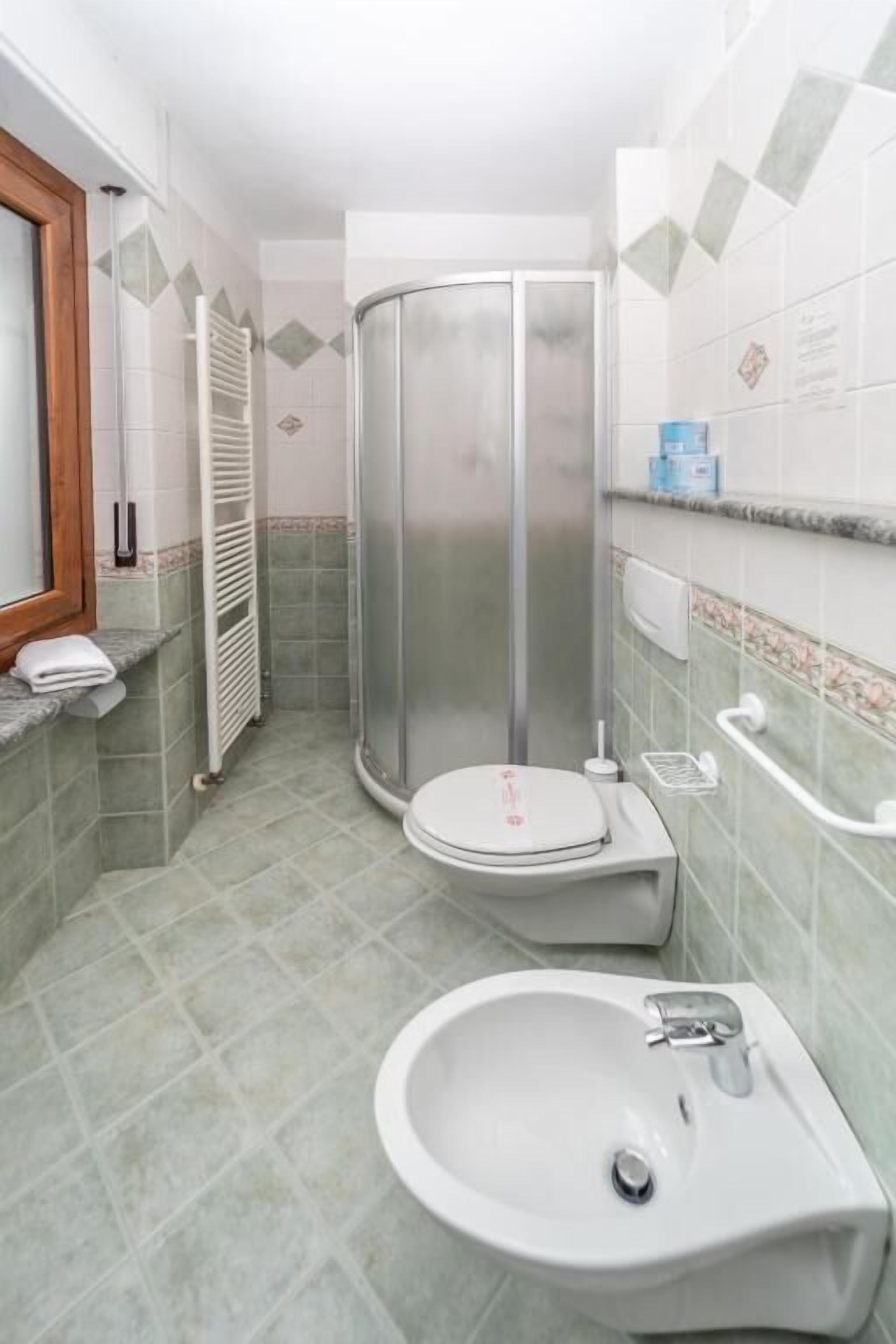 Ein Badezimmer mit Duschkabine, Toilette und Waschbecken.