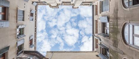 Een hoog gebouw met meerdere balkons, grote ramen en uitzicht op de lucht.