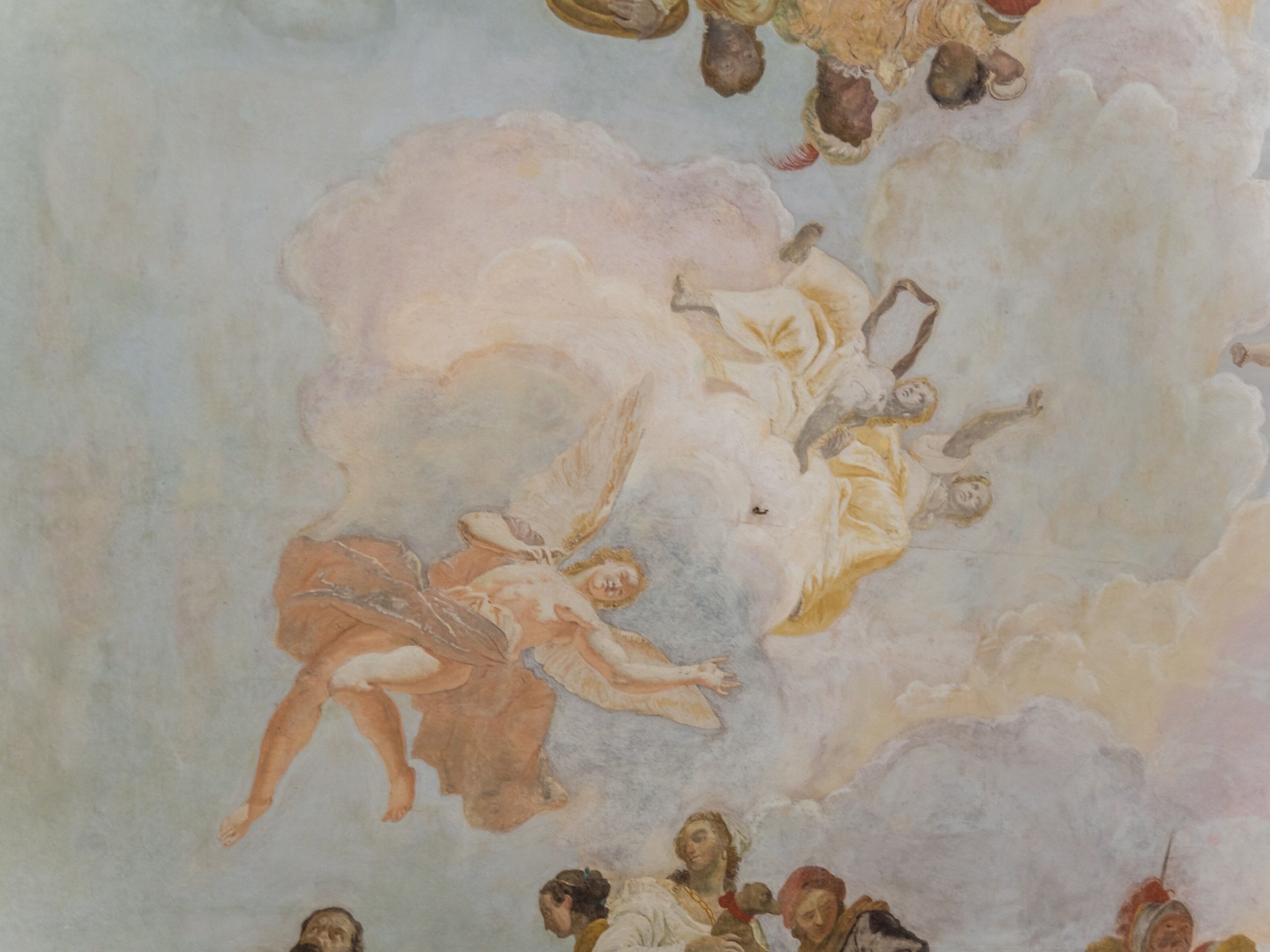 A fresco mural with figures and clouds on a ceiling.