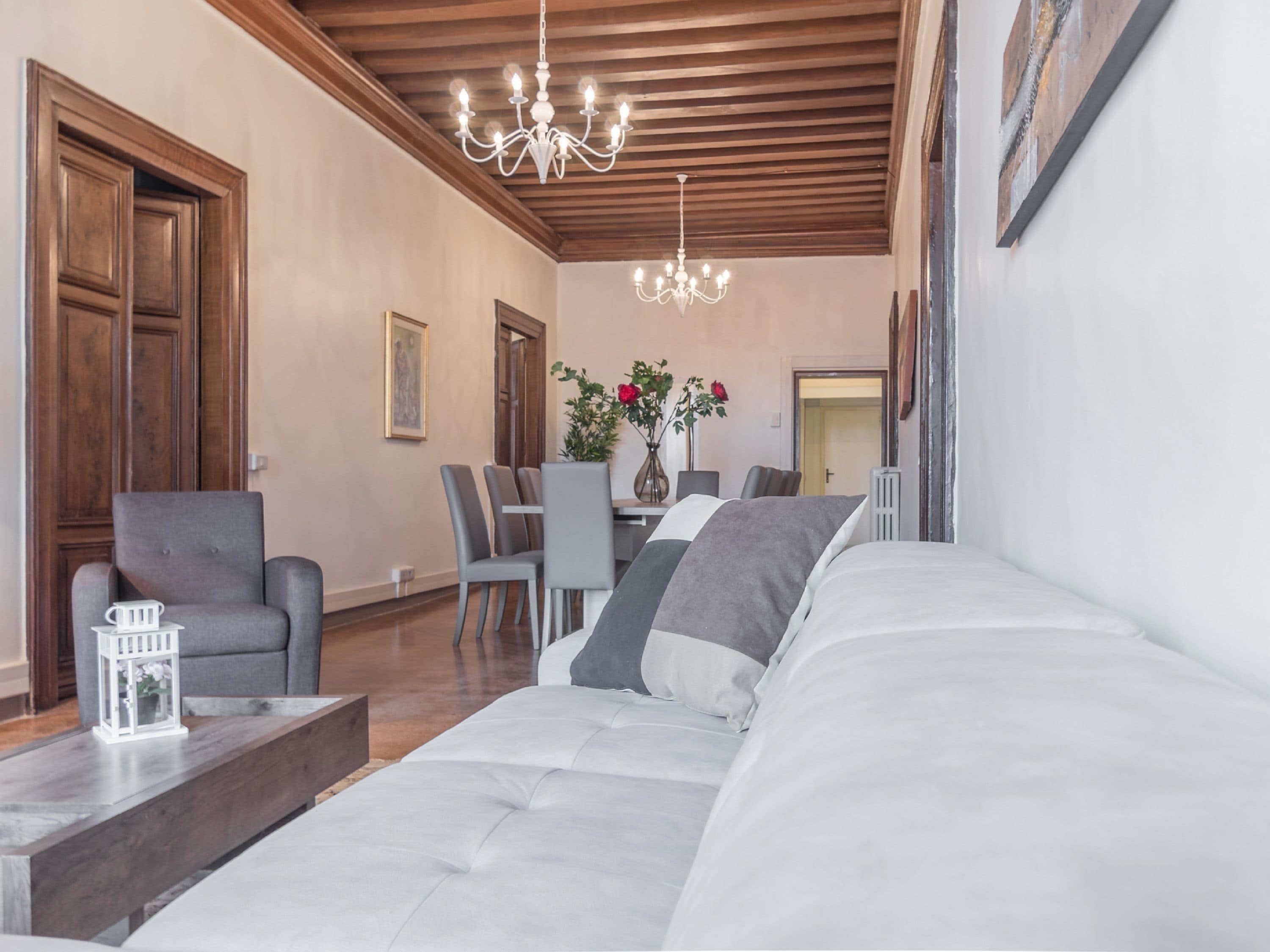 Una sala moderna con un sofá, una mesa de centro y un comedor con sillas y una mesa.