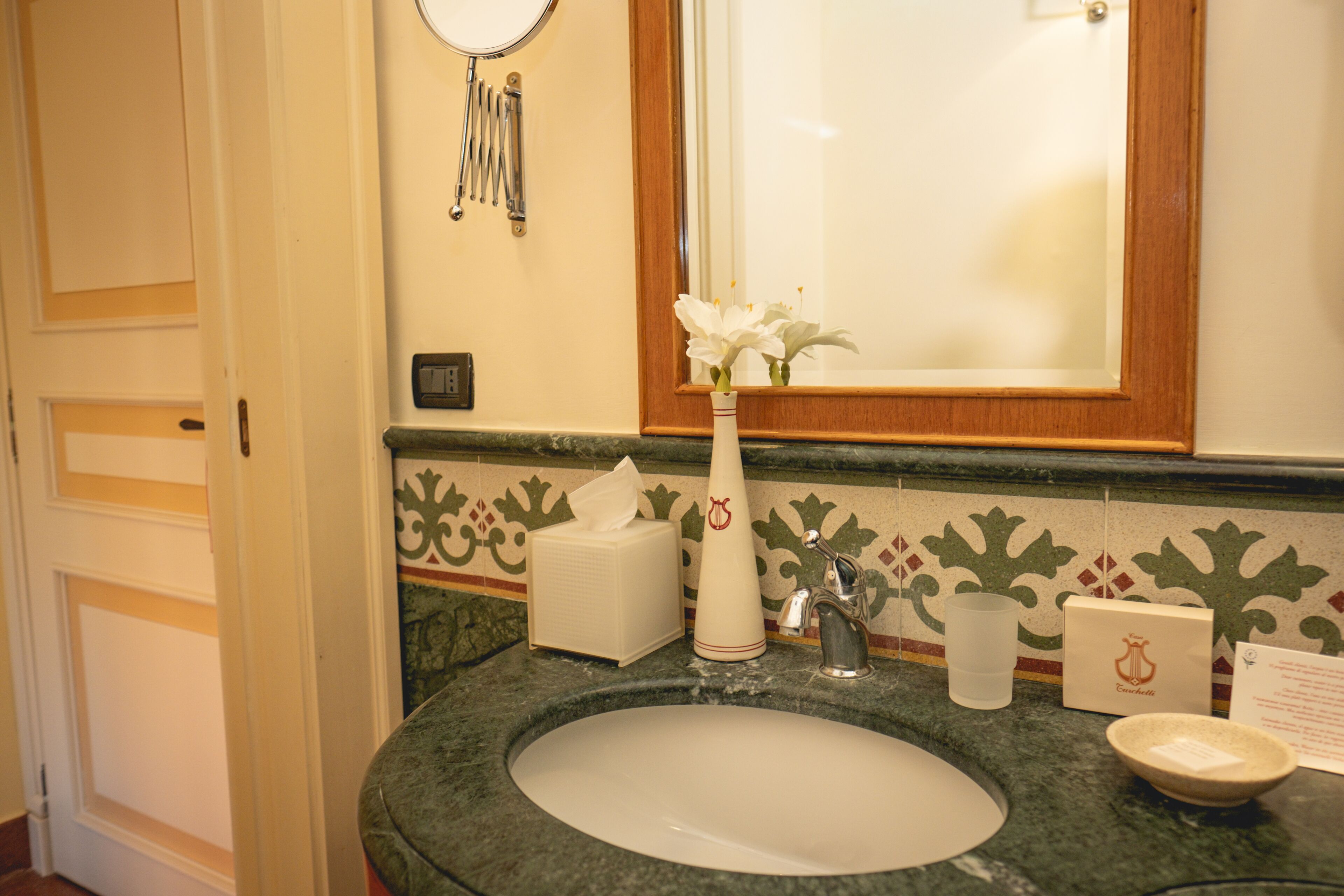 Une salle de bain avec un lavabo, un miroir et des carreaux décoratifs.