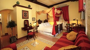 A traditional bedroom with a canopy bed, a sitting area with a sofa, and a dining table with chairs. - Casa Turchetti - Taormina (Taormina)