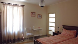 A bedroom with a bed, a desk, a chair, and a window. - Casa Cairo Affittacamere (Mombaroccio)